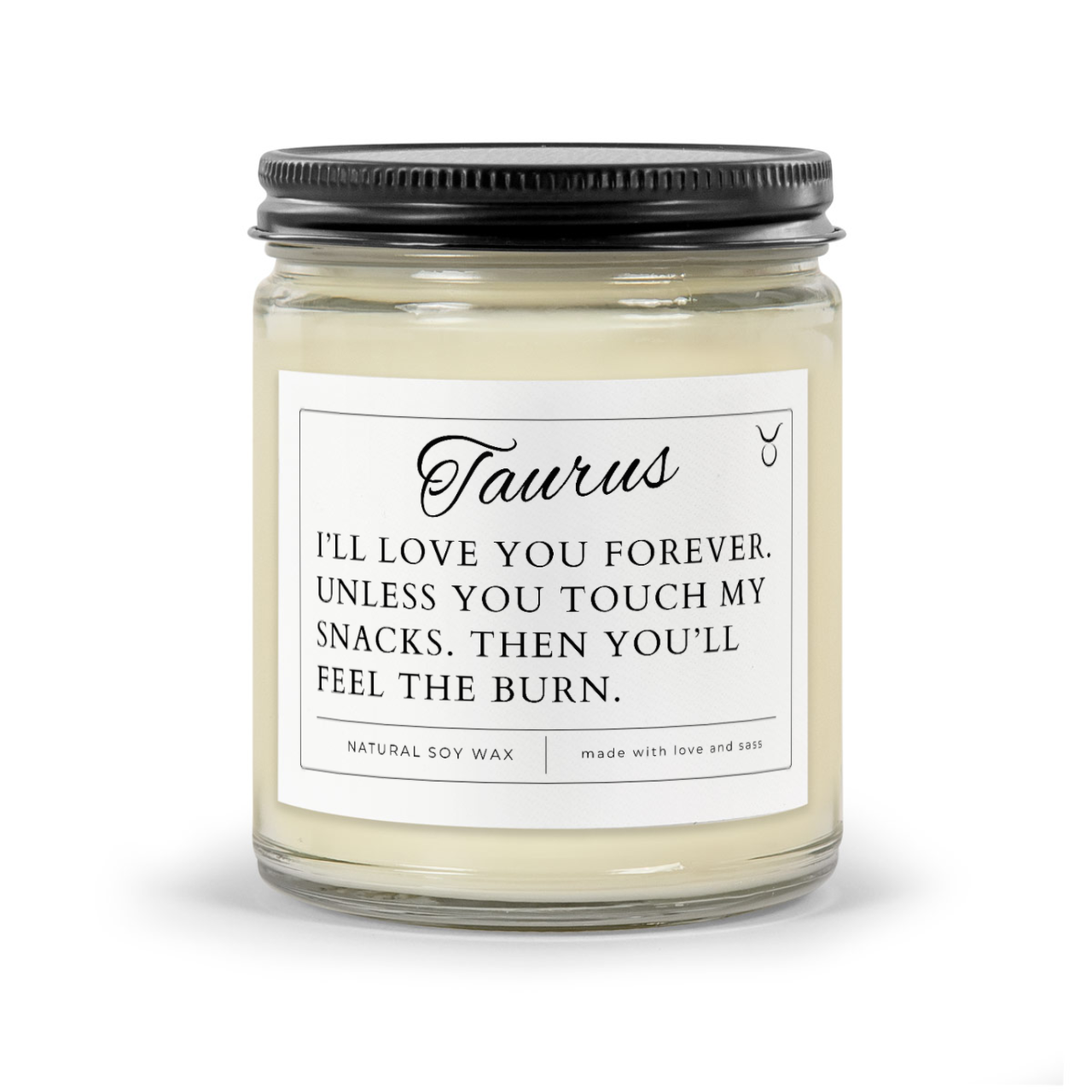 Taurus Zodiac Sign funny candle. White wax candle in 9oz clear jar with black matte lid. Label says "I'll love you forever. Unless you touch my snacks. Then you'll feel the burn"